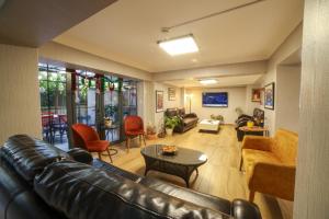 a living room with a leather couch and chairs at Palmada Hotel in Sakarya