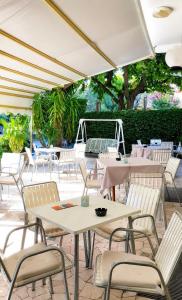 a group of tables and chairs under an umbrella at Hotel Podgora Nuova Gestione in Rimini