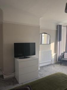 a living room with a flat screen tv on a dresser at Lakenhow in Seascale