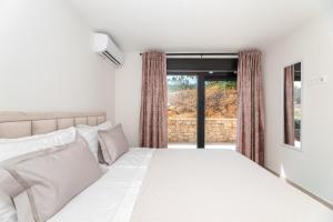 a bedroom with a white bed and a window at Villa Andrea in Splitska +50 photos