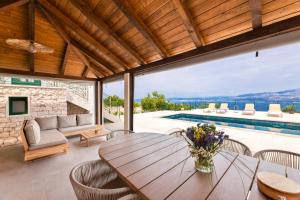 a dining room with a table and a pool at Villa Andrea in Splitska