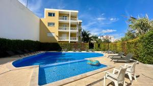 a swimming pool with chairs and a building at Garden Hill M - Shared Pool - 6 Guests - Albufeira in Albufeira