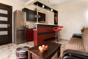 a kitchen with a refrigerator and a bowl of fruit on a table at apartament dato in Batumi