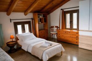 a bedroom with a bed and a dresser in a room at Villa Amalthia Panorama in Bozikás