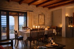a dining room with a table and chairs in a room at Villa Amalthia Panorama in Bozikás