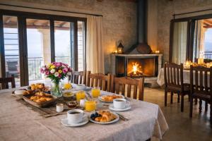 a table with breakfast foods on it with a fireplace at Villa Amalthia Panorama in Bozikás +36 photos