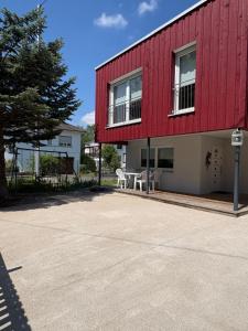 a red building with a table in front of it at Maison cosy 64 m2 à 10 min de Strasbourg, idéale familles in Lampertheim
