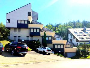 a house with two cars parked in front of it at Appartment im Schwarzwald in Furtwangen +6 photos