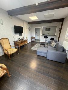 a living room with a couch and a tv at Mc privé in Châtillon-Coligny