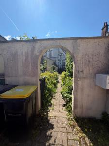an archway in a concrete wall with a garden at Mc privé in Châtillon-Coligny