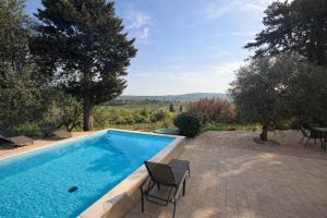 a swimming pool with chairs and a view of the countryside at Vila Porto Olive Heated Pool near Piran & Portorož in Portorož
