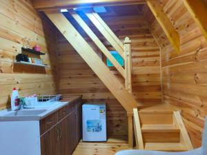a kitchen with a staircase in a log cabin at Camp Magic View in Mojkovac