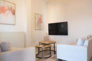a living room with a couch and a table and a tv at Evia Blue Aura in Khrónia