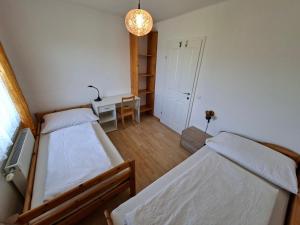 a bedroom with two beds and a desk and a table at Große Ferienwohnung im Rosental ideal für 4 bis 6 Personen mit Balkon und Garten in Maria Elend