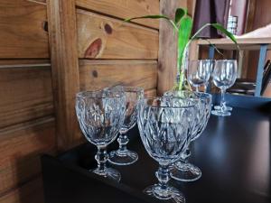a group of wine glasses sitting on a table at Chalé na Vila Do Sossego in Alfredo Wagner