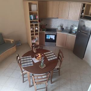 a kitchen with a table and chairs and a refrigerator at Anemomilos Villa in Asprogerakata