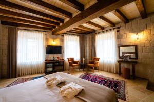 a bedroom with a bed and a desk in a room at Tulip Cave Suites in Göreme