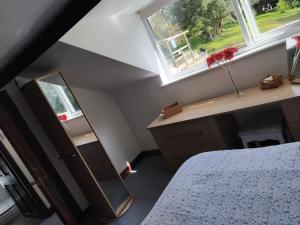 a bedroom with a bed and a mirror and a window at Tudor Cottage, Newby Bridge in Ulverston