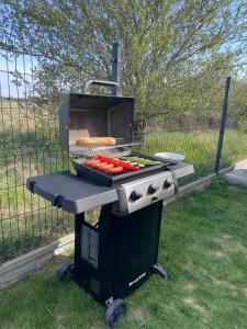 a grill with hot dogs and a bun on it at Aura Baltic in Rewal