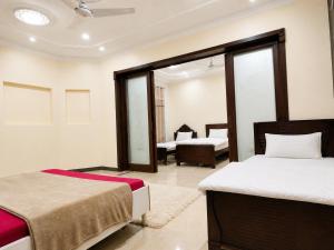a hotel room with two beds and a living room at Vision 2 Islamabad in Islamabad