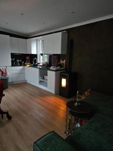 a living room with a couch and a kitchen at "Chalet Zanna" privéaccomodatie op park, begaafdzorgtse in Opende