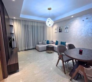 a living room with a couch and a table at Charmant studio, piscine proche mer in Aïn Harrouda