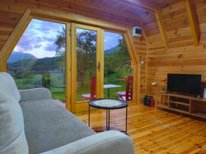 a living room with a couch and a large window at Camp Magic View in Mojkovac