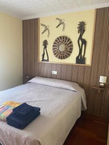 a bedroom with a bed with a mirror and palm trees on the wall at Casa Thaiker in Miami Platja