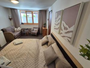 a bedroom with a large bed and a living room at Nevesta hôľ pod Chopkom in Bystrá