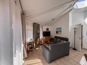 a living room with a couch and a tv at Seestern 61 in Julianadorp