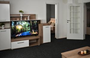 a living room with a flat screen tv on a entertainment center at Apratman Shine Kula in Kula +4 photos