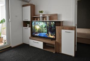 a tv in a entertainment center in a room at Apratman Shine Kula in Kula