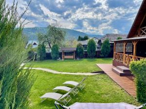 a group of lawn chairs sitting on a deck at Cabana Panoramic Bicaz in Hangul +42 photos