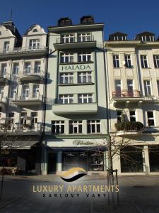 a large building with a sign in front of it at Halada house apartments in Karlovy Vary