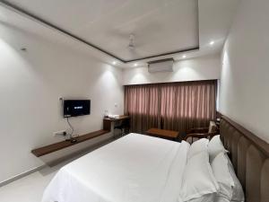 a hotel room with a bed and a television at MRP Residency in Chitradurga