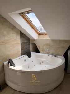 a large white bath tub in a bathroom with a skylight at Luxury Apartments in Brčko
