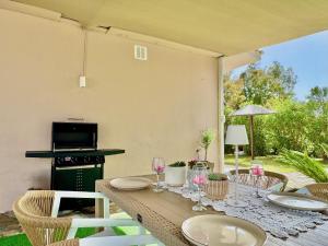 a table with plates and wine glasses on a patio at Villa Sunray Sidari with private pool by DadoVillas in Sidari