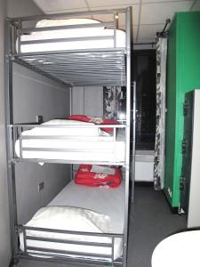 a room with three bunk beds in a room at Peace & Love Hostel in Paris