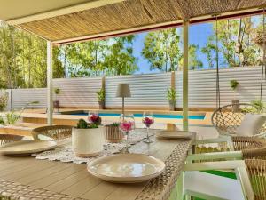 an outdoor table with plates and chairs on a deck at Villa Sunray Sidari with private pool by DadoVillas in Sidari