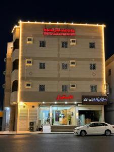 a white car parked in front of a building at شقق عناوين الفخامة in Şāmitah