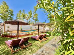 a group of chairs and umbrellas next to a pool at Villa Sunray Sidari with private pool by DadoVillas in Sidari