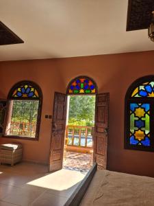 a room with three stained glass windows and a bed at Casa Sofia in Meknès