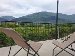 two chairs on a balcony with mountains in the background at Apartmani Emma II in Gobovići