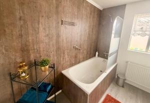 a bathroom with a bath tub in a room at Nýlenda - Charming Two Bedroom Seaside Property, Mountain and Town Views in Seyðisfjörður +30 photos