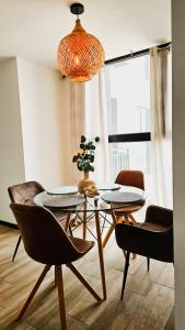 a dining room with a table and chairs and a potted plant at Luxury Skyline Apartment with pool, city views & volcano views in El Rodeo