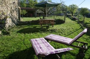 a picnic table and two chairs and an umbrella at Gite Le Banchet in Truinas