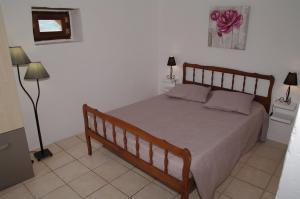 a bedroom with a bed with a wooden frame and two lamps at Gite Le Banchet in Truinas