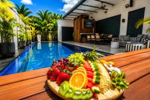 a plate of fruit on a table next to a pool at Royal Water Villa in Kiryat Ekron