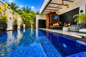an infinity pool in a villa with palm trees at Royal Water Villa in Kiryat Ekron