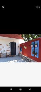 a red and white building with a blue door at gialos house in Livadia
